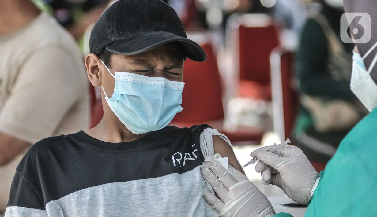 Ekspresi seorang anak saat menerima vaksin Covid-19 dalam program Vaksinasi Keliling di RPTRA Pulo Besar, Sunter Jaya, Jakarta, Selasa (12/7/2021). Kementerian Kesehatan mengalokasi 20 juta dosis vaksin Covid-19 untuk anak usia 12-17 tahun yang diberikan secara bertahap (merdeka.com/Iqbal S Nugroho)