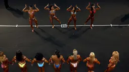 Peserta wanita kontes binaraga menunjukkan lekuk tubuhnya dihadapan penonton dan juri pada kontes Arnold Klasik Eropa 2015 di Madrid, Spanyol, Jumat (25/9). (REUTERS/Susana Vera)