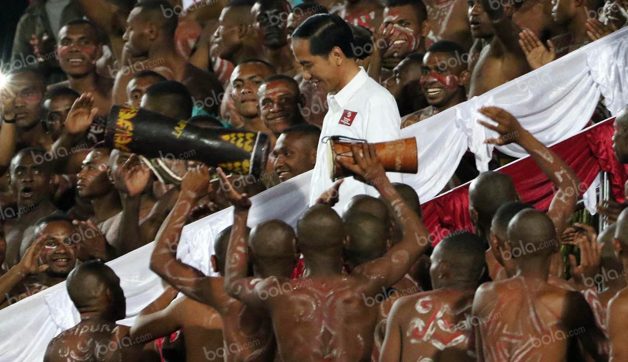 Presiden Joko Widodo, bersiap membuka babak kedua pertandingan antara Persipura melawan Persija pada laga Torabika Soccer Championship 2016 di Stadion Mandala, Jayapura, Jumat (29/4/2016). (Bola.com/Nicklas Hanoatubun)