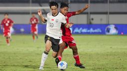 Pemain Timnas Indonesia U-17, Dava Yunna mencoba merebut bola dari pemain China U-17, Jing Feng dalam pertandingan uji coba internasional di Indomilk Arena, Tangerang, pada Rabu (11/2/2026) malam WIB. (Bola.com/Abdul Aziz)