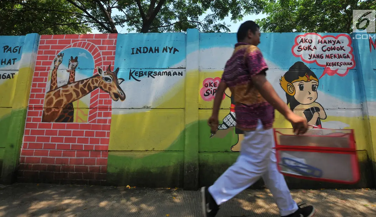 Warga melintas di 'Gang Mural', Kelurahan Rorotan, Jakarta, Kamis (29/3). Mural ini bertujuan mempercantik serta menambah kesan asri gang selebar 2 meter tersebut. (Merdeka.com/Iqbal S Nugroho)
