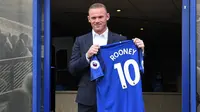 Penyerang baru Everton Wayne Rooney, memegang kostum tim barunya setelah konferensi pers di Goodison Park di Liverpool (10/8). Wayne Rooney dibeli Everton dari Manchester United. (AFP Photo/Paul Ellis)