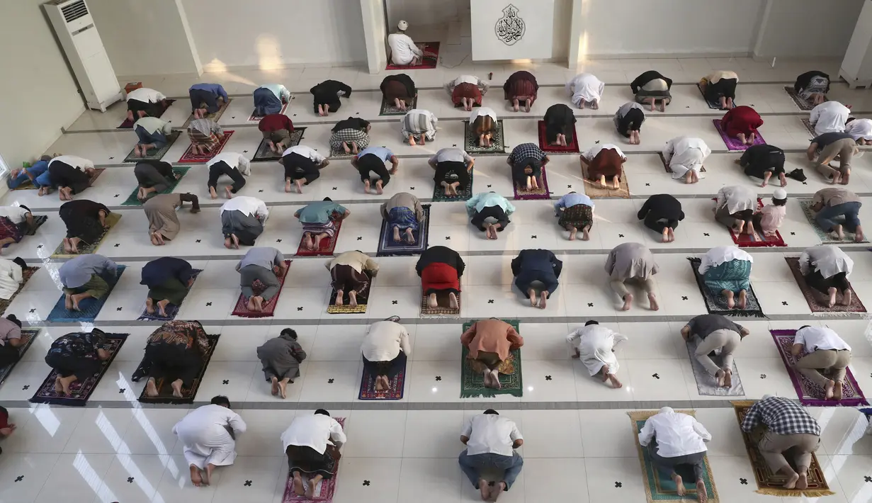 Umat muslim melaksanakan salat Idul Adha dengan menerapkan jaga jarak untuk mencegah penularan virus corona COVID-19 di Masjid Zona Madina, Bogor, Jawa Barat, Selasa (20/7/2021). Umat muslim Indonesia melewati Hari Raya Idul Adha tahun ini di tengah gelombang COVID-19. (AP Photo/Tatan Syuflana)