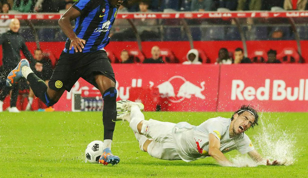 Pemain RB Salzburg, Roko Simic (kanan) terjatuh setelah berebut bola dengan pemain Inter Milan, Yann Aurel Bisseck pada laga uji coba pramusim di Red Bull Arena, Austria, 10 Agustus 2023 WIB. (AFP/APA/Krugfoto)