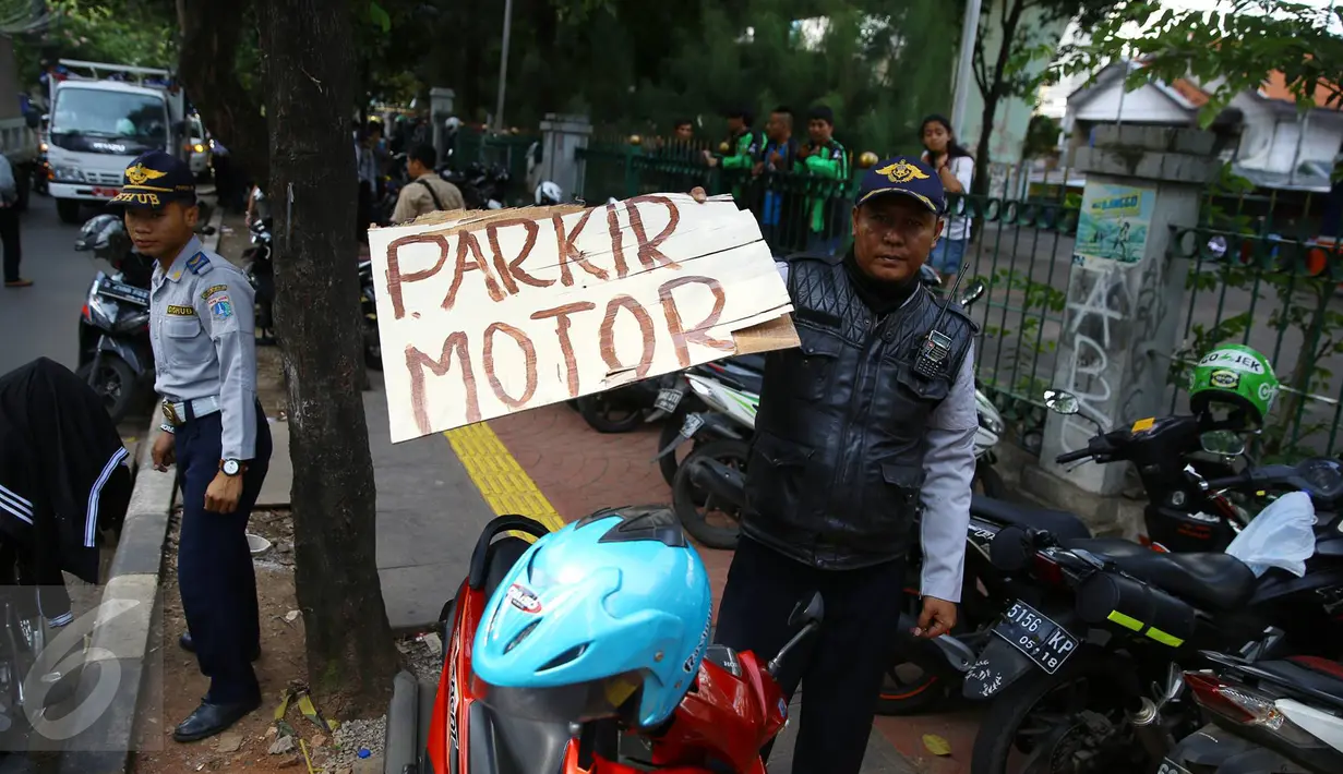Petugas Dishub saat melakukan razia parkir liar di sepanjang trotoar kawasan Kebon Sirih, Jakarta, Rabu (18/1). Puluhan motor diamankan serta digembosi dalam penertiban tersebut karena menutupi jalur pedestrian. (Liputan6.com/Immaniel Antonius)