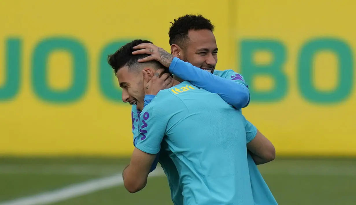 Pemain Brasil Neymar (kanan) memeluk rekan setimnya Gabriel Martinelli saat sesi latihan di pusat pelatihan Granja Comary, Teresopolis, Brasil, 23 Maret 2022. Brasil akan menghadapi Chile pada pertandingan sepak bola kualifikasi Piala Dunia 2022 di Rio de Janeiro. (AP Photo/Silvia Izquierdo)