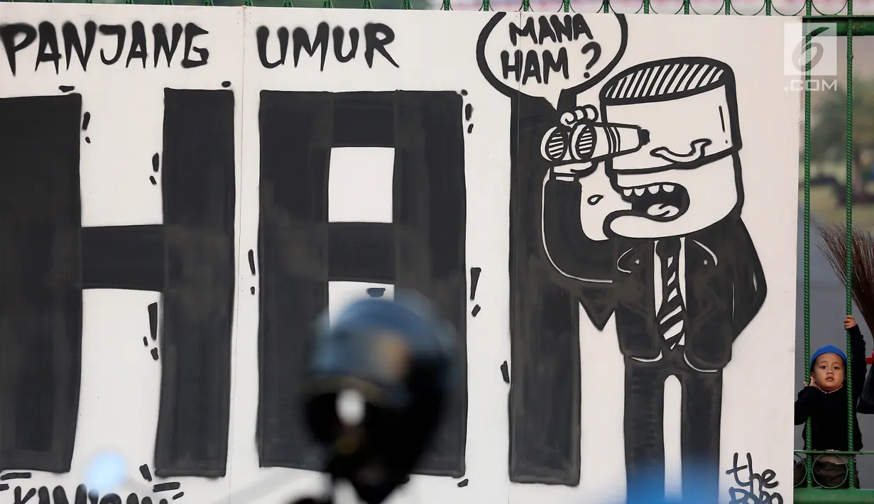 Mural bertuliskan "Mana HAM" terpampang saat aksi Kamisan ke-502 di seberang Istana Merdeka, Jakarta, Kamis (10/8). Aksi meminta pemerintah mewujudkan komitmen dalam menyelesaikan kasus pelanggaran HAM berat pada masa lalu. (Liputan6.com/Johan Tallo)