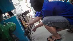 Seorang tersangka memasukkan sabu dan ganja ke dalam mesin penghancur di halaman Gedung BNN, Kamis (14/8/14). (Liputan6.com/Faizal Fanani)
