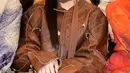 Giselle Aespa mengenakan dress dan jaket kulit warna coklat saat hadir di Acne Studios. [@aerichandesu]