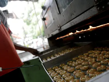 Pekerja saat memanggang kue kering di sebuah industri rumahan di Kawasan Kwitang, Jakarta, Jumat (30/4/2021). Pandemi Covid-19 yang masih terjadi berimbas pada industri rumahan kue kering tersebut. (Liputan6.com/Faizal Fanani)