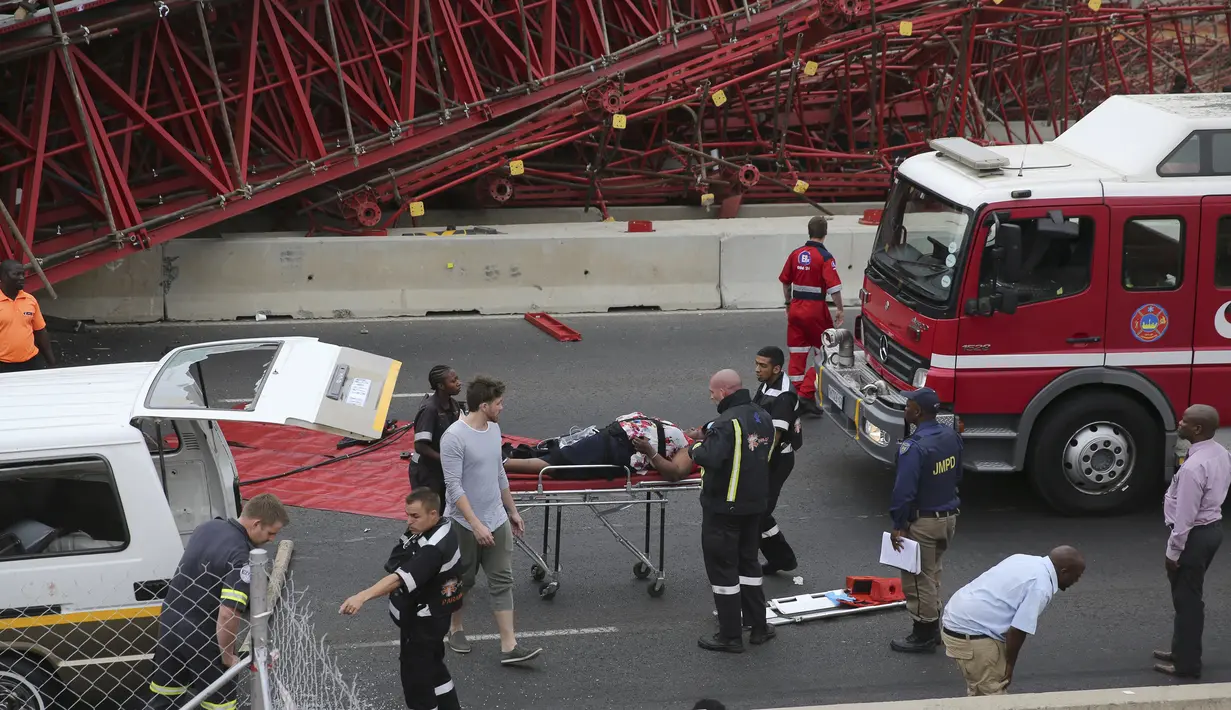 Paramedis mengevakuasi korban ambruknya perancah atau scaffolding jembatan yang sedang dibangun di jalan tol M1 menuju Sandton, Afsel, Rabu (14/10). Kejadian itu menewaskan dua orang dan 20 lainnya cedera, menurut kantor SAR lokal (REUTERS/Siphiwe Sibeko)