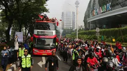 Bus yang ditumpangi Timnas Indonesia U-22 melewati pusat perbelanjaan Senayan Park saat pawai kontingen Indonesia untuk SEA Games 2023 yang bertajuk Kira87uara yang berlangsung di Jakarta, Jumat (19/05/2023). (Bola.com/Bagaskara Lazuardi)
