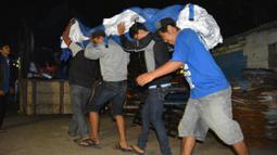 Bendera merah putih raksasa diangkat anggota Aremania menuju truk pengangkut yang akan membawa ke Malang dan Bali. (Bola.com/Aremania)