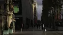 Seorang pria memakai masker saat melintas di jalan Champs Elysee, Paris, Kamis (19/11/2020). Prancis telah melampaui 2 juta kasus virus corona COVID-19 yang dikonfirmasi, total tertinggi keempat di dunia. (AP Photo/Thibault Camus)