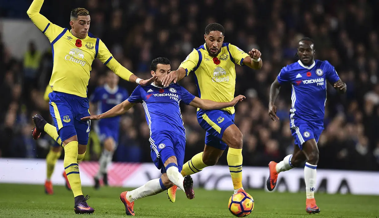 Gelandang Chelsea, Pedro, berusaha melewati hadangan pemain Everton pada laga Premier League di Stamford Bridge Stadium, Inggris, Sabtu (11/2016). Chelsea menang 5-0 atas Everton. (AFP/Glyn Kirk)