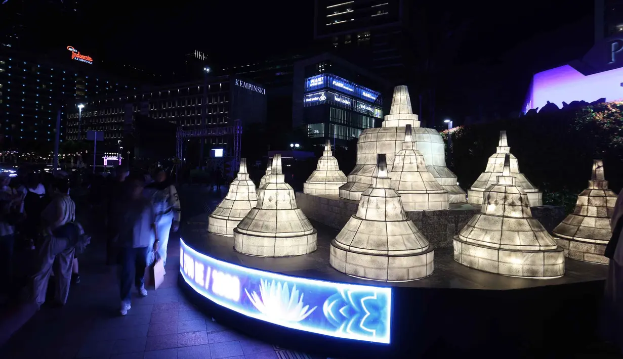 Warga berjalan di dekat ornamen lampu hias saat llumination of Jakarta: Glow of Peace di kawasan Bundaran Hotel Indonesia, Jakarta, Kamis (28/5/2026). (Kapanlagi.com/Budy Santoso)