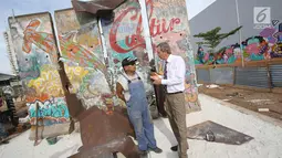 Seniman Teguh Ostenrik (kiri) berbincang dengan Dubes Jerman untuk Indonesia Michael Freiherr von Ungern-Sternberg saat pemasangan pecahan Tembok Berlin dan Patung Menembus Batas di RPTRA Kalijodo, Jakarta, Selasa (26/9). (Liputan6.com/Immanuel Antonius)