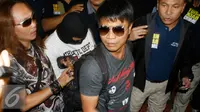 Petugas mengawal Tersangka mutilasi wanita hamil, Kusmayadi alias Agus bin Dulgani diamankan Polda Metro Jaya, Bandara Soetta, Tangerang, Kamis (21/4). (Liputan6.com/ Pramita Tristiawati) 