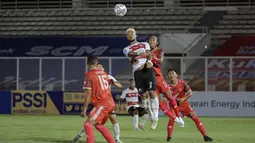 Pemain Madura United, Rafael Feital Da Silva (tengah) berebut bola diudara dengan pemain PSM Makassar, Erwin Gutawa saat laga BRI Liga 1 2021/2022 antara Madura United melawan PSM Makassar di Stadion Madya, Jakarta, Minggu (12/9/2021). Pertandingan berakhir imbang 1-1. (Foto: Bola.com/Ikhwan Yanuar)