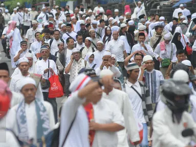 Puluhan orang berjalan kaki menuju Monas dari arah Tanah Abang, Jakarta, Jumat (2/12). Mereka terlihat berbondong-bondong berjalan untuk mengikuti demo 2 Desember di Lapangan Monas. (Liputan6.com/Helmi Afandi)