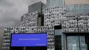 Potret para petugas kesehatan yang ditempelkan di bagian depan Bastille Opera di Paris, Prancis, Jumat (10/7/2020). Potret hitam putih untuk memberi penghormatan kepada pekerja medis Covid-19 itu merupakan kreasi seniman Prancis dan fotografer JR. (AP Photo/Francois Mori)