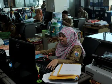 Sejumlah Pegawai Negeri Sipil (PNS) melakukan aktivitas di kantor Balai Kota DKI, Jakarta, Rabu (22/7/2015). Hari ini adalah hari pertama masuk kerja di lingkungan Pemerintah Daerah Jakarta pasca cuti bersama Idul Fitri 1436H. (Liputan6.com/Johan Tallo)