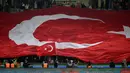 Pendukung Turki membentangkan bendera raksasa saat laga Grup D Kualifikasi Euro 2024 melawan Latvia di Konya Buyuksehir Belediye Stadium, Konya, Turki, Senin (16/10/2023) dini hari WIB. (AFP/Ozan Kose)
