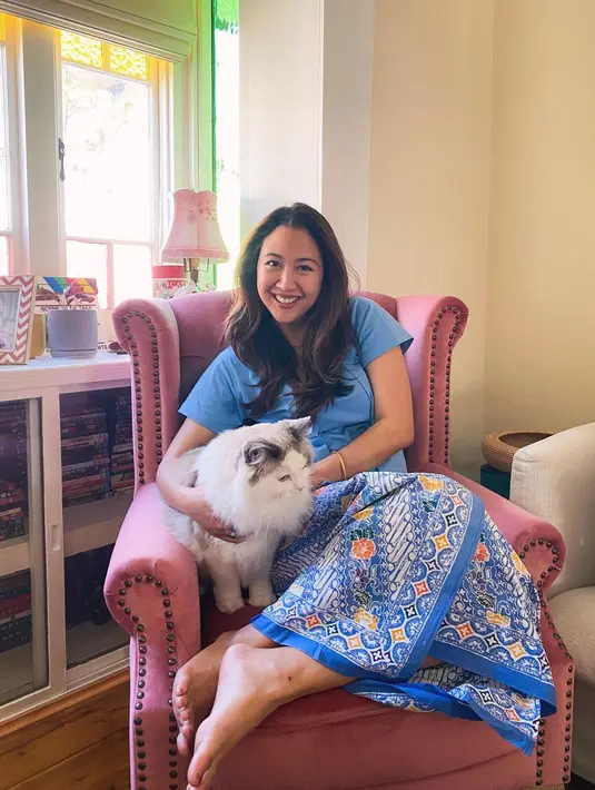 Berpose duduk bersama kucing peliharaannya, Sherina kembali tampil cantik mengenakan batik. Ia memadukan atasan bersiluet kebaya kutubaru berwarna biru polos dengan kain batik biru yang serasi. [Foto: Instagram/sherinamunaf]