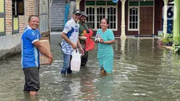 Insan BRILiaN (karyawan BRI) mendistribusikan makanan cepat saji kepada warga terdampak banjir di Kecamatan Ngusikan, Jombang, Jawa Timur, Minggu (13/03/2022). BRI juga bekerja sama dan berkoordinasi dengan berbagai pihak untuk bersinergi dalam menyalurkan bantuan. (Liputan6.com/HO/CSRBRI)