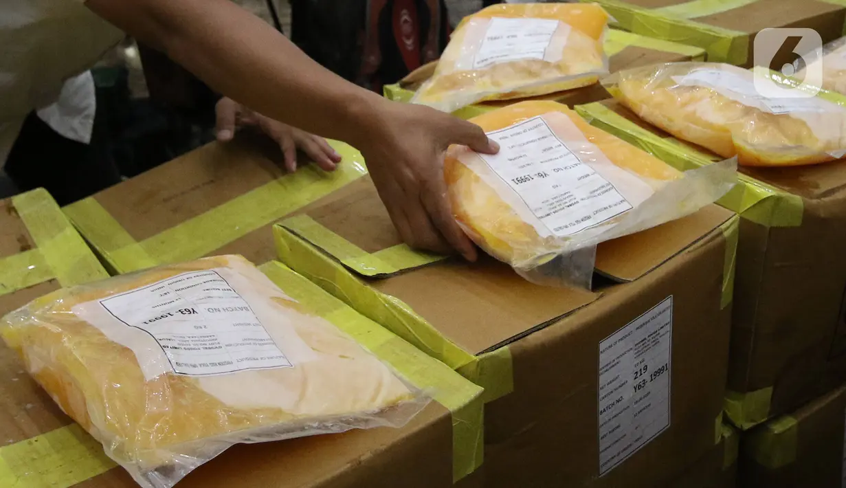 Petugas marapikan barang bukti dalam rilis kasus importasi kuning telur beku di Bareskrim Polri, Jakarta, Rabu (12/2/2020). Dittipideksus Polri berhasil mengungkap dugaan pelanggaran importasi Frosen Egg Yolk-10 persen asal India tanpa dokumen perizinan impor. (Liputan6.com/Angga Yuniar)