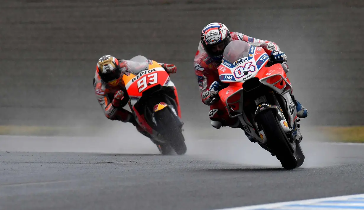 Pembalap Ducati, Andrea Dovizioso (kanan) saat bersaing dengan pembalap Honda, Marc Marquez di MotoGP Jepang di sirkuit Motegi, (15/10). Dovizioso  juara usai terlibat duel sengit dengan Marc Marquez di tikungan terakhir. (AFP Photo/Toshifumi Kitamura)