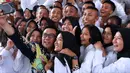 Menpora Imam Nahrawi (tengah) berswafoto bersama peserta Diklat Paskibraka Nasional 2018 di Wisma Soegondo Cibubur, Jakarta, Kamis (26/7). Diklat diikuti 68 siswa terbaik dari 34 provinsi di Indonesia. (Liputan6.com/Helmi Fithriansyah)