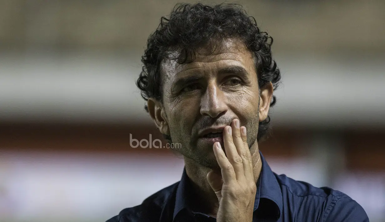 Luis Milla mencoba menghilangkan rasa tegang dengan memainkan tangannya sambil melihat ke tribun penonton. (Bola.com/Vitalis Yogi Trisna)