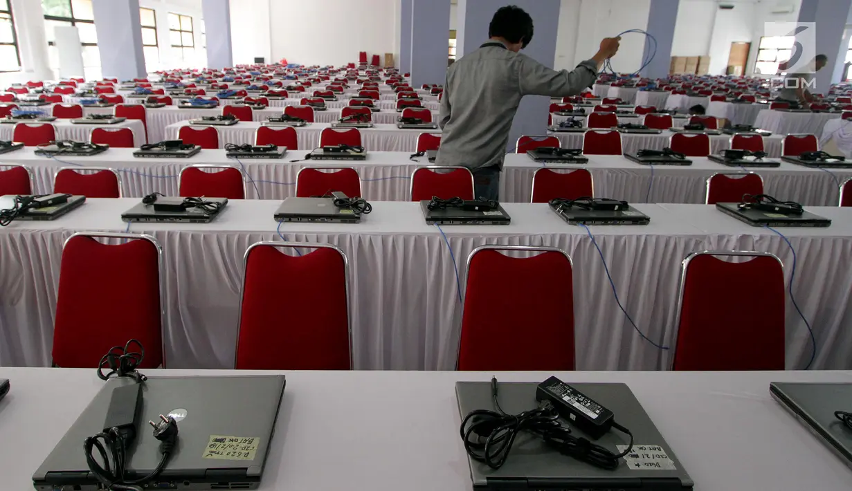 Teknisi menginstal laptop untuk tes calon pegawai negeri sipil (CPNS) di GOR Kelapa Gading, Jakarta Utara, Jumat (26/10). Tempat ini akan menjadi lokasi tes CPNS yang akan dilangsungkan pada Sabtu, 26 Oktober 2018. (Liputan6.com/JohanTallo)