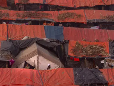 Seorang pria Muslim Rohingya berjalan melewati tenda-tenda pengungsian di kamp pengungsi Jamtoly, Bangladesh (15/1). Etnis Rohingya yang mengungsi di Bangladesh akan segara dipulangkan ke Myanmar.  (AP Photo / Manish Swarup)