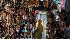 Seorang penjaga toko menata sepatu di Gauhati, India, Rabu (9/6/2021). India melonggarkan sebagian pembatasan untuk mengekang penyebaran virus corona COVID-19. (AP Photo/Anupam Nath)