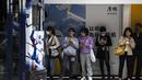 Orang-orang menunggu trem di Hong Kong  (1/3/2023). Pencabutan penggunaan masker sebagai salah satu upaya Hong Kong untuk menarik dan menyambut wisatawan dan pembisnis pasca aturan ketat hampir selama tiga tahun. (AFP/Isaac Lawrence)