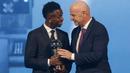 Presiden FIFA, Gianni Infantino memberikan penghargaan pemain pria terbaik FIFA 2024 kepada pemain Real Madrid, Vinicius Jr dalam acara yang berlangsung di oha, Qatar pada Selasa (18/12) malam waktu setempat. (AFP/Karim Jaafar)