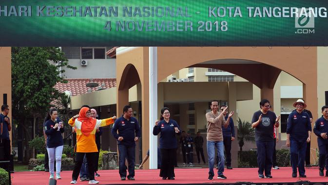 Presiden Joko Widodo (Jokowi) ditemani Koordinator Staf Khusus Presiden Teten Masduki memandu senam bersama di depan Kantor Wali Kota Tangerang, Minggu (4/11). Kegiatan itu dalam rangka perayaan Hari Kesehatan Nasional ke-54. (Liputan6.com/Johan Tallo)