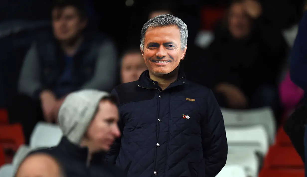Suporter menggunakan topeng pelatih Chelsea Jose Mourinho pada laga Liga Premier Inggris di Stadion Britania, Minggu (8/11/2015) dini hari WIB. Mourinho dilarang mendampingi timnya oleh Football Association ( FA ). (AFP Photo/PAUL Ellis)