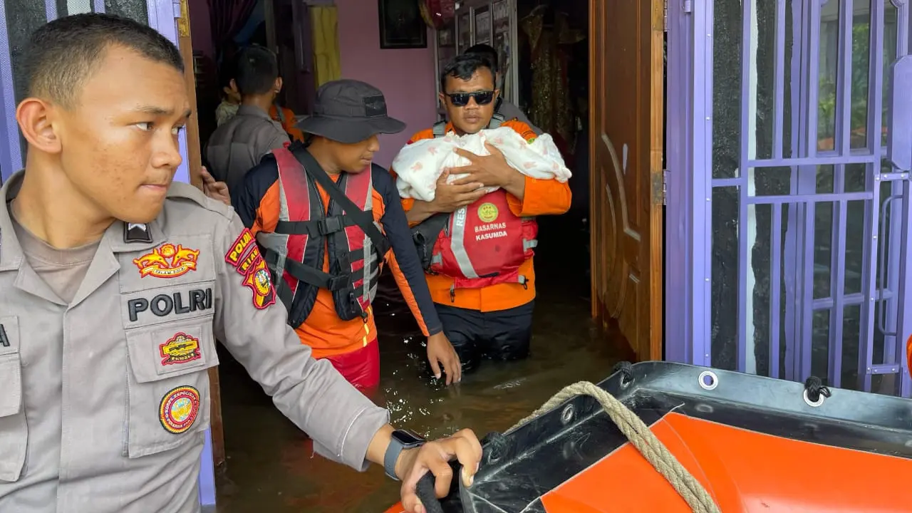 Petugas gabungan mengevakuasi korban bencana banjir di Pekanbaru.
