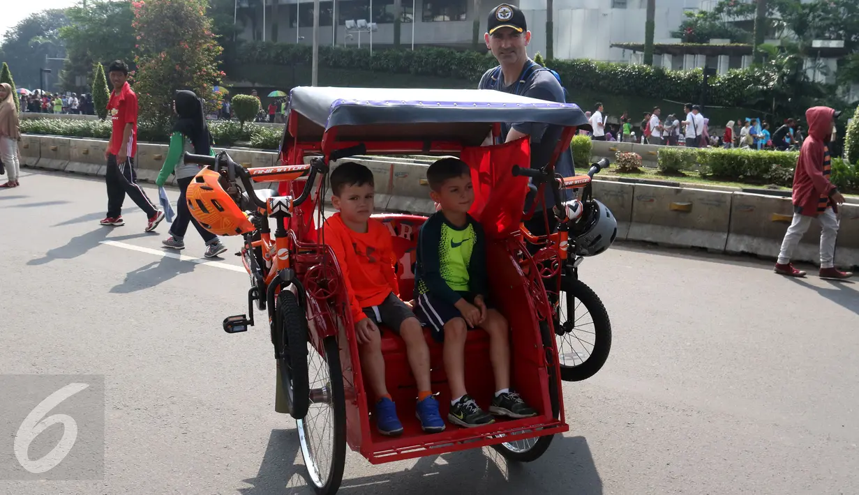Seorang Warga Negara Asing berpose di depan becak yang dikendarainya saat Hari Bebas Kendaraan di Kawasan Bundaran HI, Minggu (7/5). Ia juga terlihat anak-anak di becaknya. (Liputan6.com/Helmi Fithriansyah)