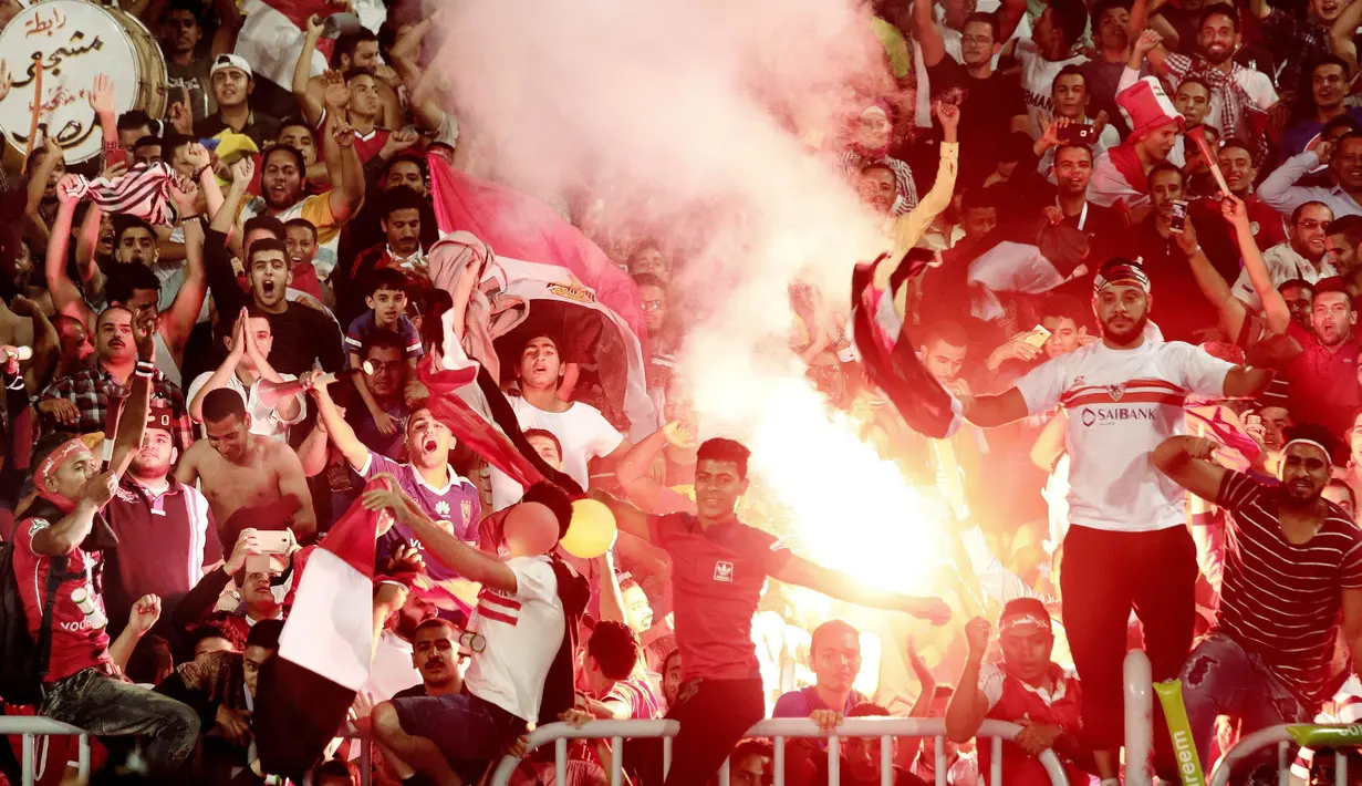 Para suporter Mesir menyalakan flare merayakan keberhasilan negaranya lolos ke Piala Dunia 2018 di Stadion Borg El Arab, Alexandria, Senin (8/10/2017). Mesir lolos ke Piala Dunia setelah absen sejak gelaran tahun 1990. (AP/Nariman El-Mofty)