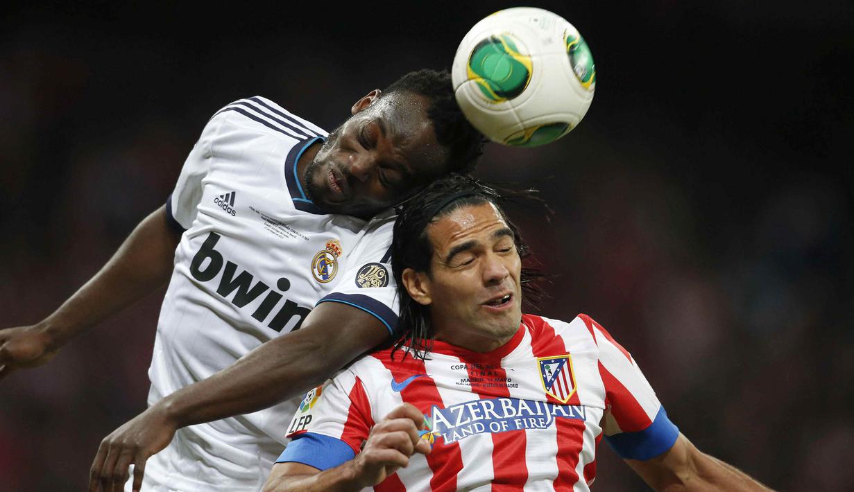 Gelandang Real Madrid, Michael Essien, duel udara dengan striker Atletico Madrid, Falcao. Setelah meraih sukses bersama The Blues, pemain asal Ghana ini sempat dipinjamkan ke Real Madrid pada tahun 2012. (EPA/Juan Carlos Hidalgo)