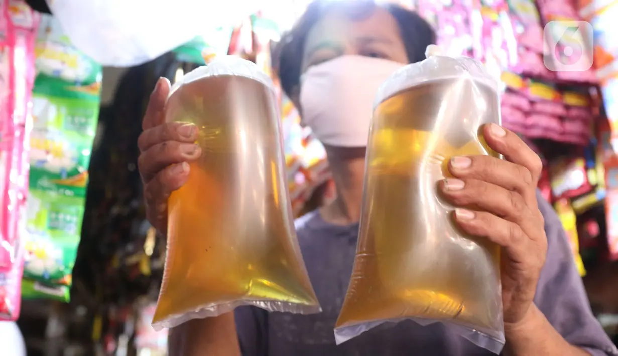 Pedagang menunjukkan minyak curah yang dijual di pasar di Kota Tangerang, Banten, Kamis (25/11/2021). Pemerintah melarang peredaran minyak goreng curah ke pasar per tanggal 1 Januari 2022. (Liputan6.com/Angga Yuniar)
