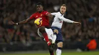 Paul Pogba berduel dengan Christian Eriksen pada laga lanjutan Premier League yang berlangsung di stadion Wembley, Inggris, Minggu (13/1). Man United menang atas Tottenham Hotspur 1-0. (AFP/Adrian Dennis)
