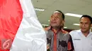 Jannes Johan Karubaba membawa Bendera Indonesia saat akan menjalani sidang, Jakarta, Senin (13/7/2015). Karubaba diduga melakukan korupsi pengadaan "Detailing Engineering Design" di Sungai Mamberamo dan Urumka. (Liputan6.com/Helmi Afandi)