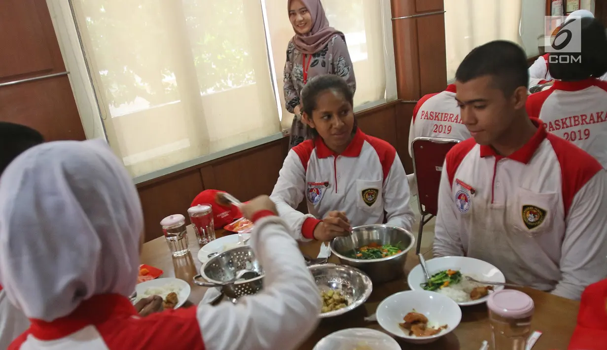 Sejumlah calon anggota Pasukan Pengibar Bendera (Paskibra) Nasional 2019 menikmati makan siang usai mengikuti latihan di PPPON Cibubur, Jakarta, Selasa (30/7/2019). Saat ini, 68 orang anggota Paskibraka nasional 2019 sedang menjalani pendidikan dan pelatihan intensif. (Liputan6.com/Herman Zakharia)