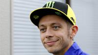 Pebalap Yamaha Movistar, Valentino Rossi, melempar senyum saat mendatangi paddock di Sirkuit Motegi, Tochigi Prefecture, Kamis (12/10/2017). MotoGP Jepang akan bergulir pada Minggu ini. (AP/Shizuo Kambayashi)