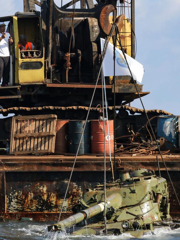 Aktivis lingkungan menenggelamkan sebuah tank lama ke dasar Laut Mediterania di lepas pantai kota pelabuhan Sidon, Lebanon, Sabtu (28/7). Mereka menenggelamkan 10 tank lama yang disediakan oleh Angkatan Bersenjata Lebanon. (AFP / Mahmoud ZAYYAT)